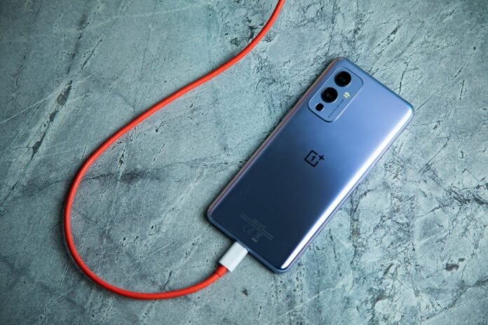 Buying a New iPhone or Android Phone? Consider These Things Oneplus 9 phone plugged into a charging cable