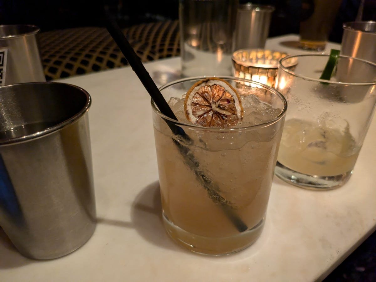 Google Pixel 8A Review: A Clear Choice Over the Pixel 8 14 A cocktail on a table in a dim bar.