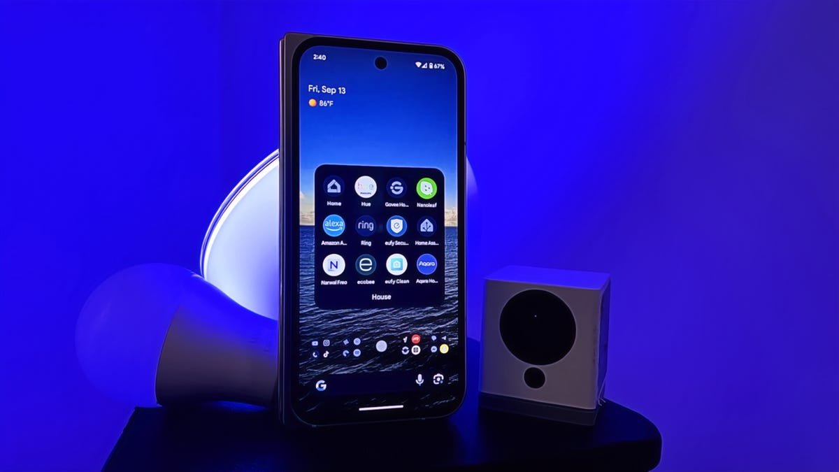 Google Pixel 9 Pro Fold showing 12 smart home apps by some smart lights and a camera.