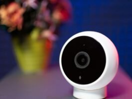 An Apple smart home camera will combine privacy with Apple Intelligence (Xiaomi camera shown on desk with flowers in vase)