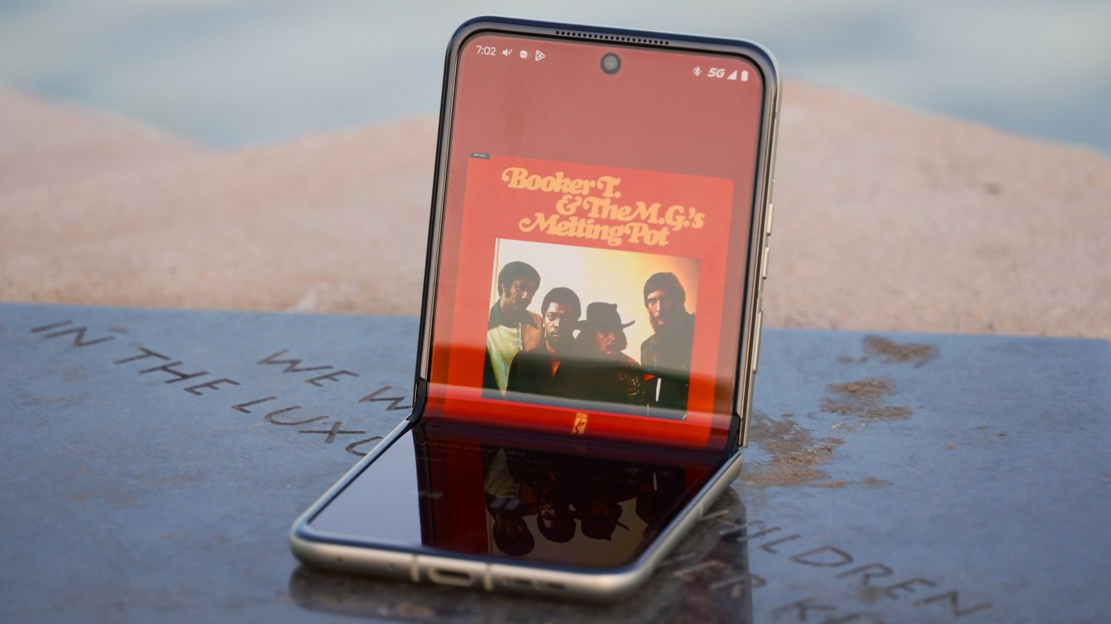 The Motorola Razr 2025 half-opened with Apple Music playing.