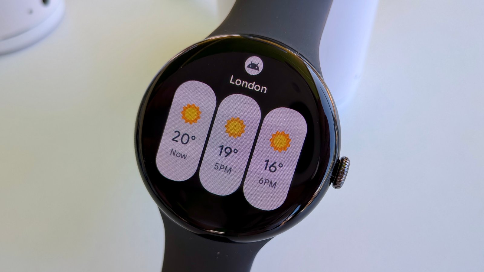The new Weather tile on Wear OS 6, showing three narrow tiles for Now, 5PM, and 6PM temperatures in London.