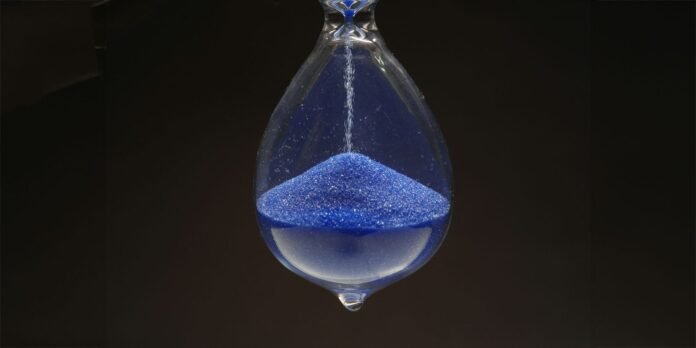 Apple says EU law means more delayed features, maybe even Apple says EU law will mean more features are delayed, maybe even new hardware | Close-up photo of hourglass with blue sand
