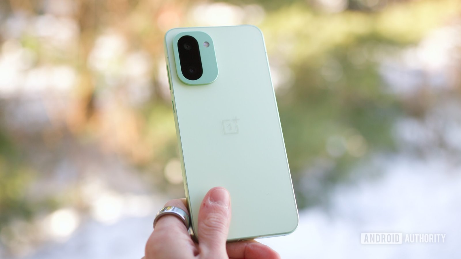 Someone holding the OnePlus 15R, showing the back of the phone.