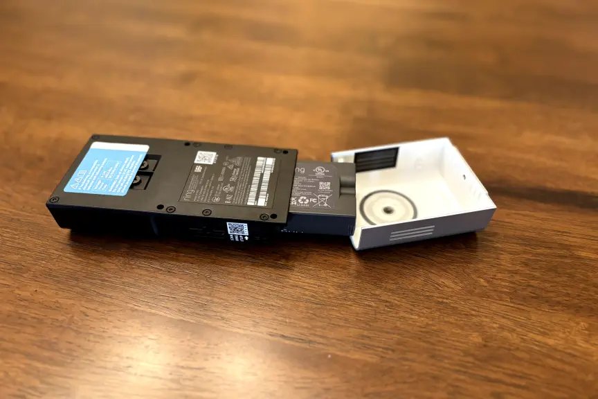 A doorbell battery on a wood table. 