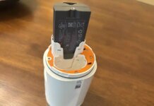 Can Smart Home Devices Catch on Fire? I Researched the Facts You Should Know A Ring spotlight camera showing its battery slots with a battery halfway out.