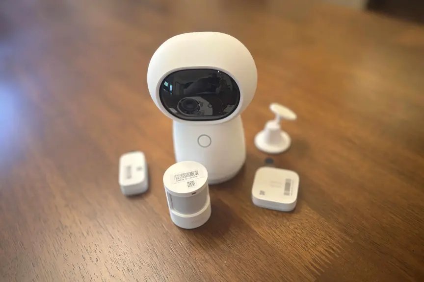 Best Apple Siri Voice Commands for Your Home: A Complete Guide 1 Aqara white camera system on a wood table.