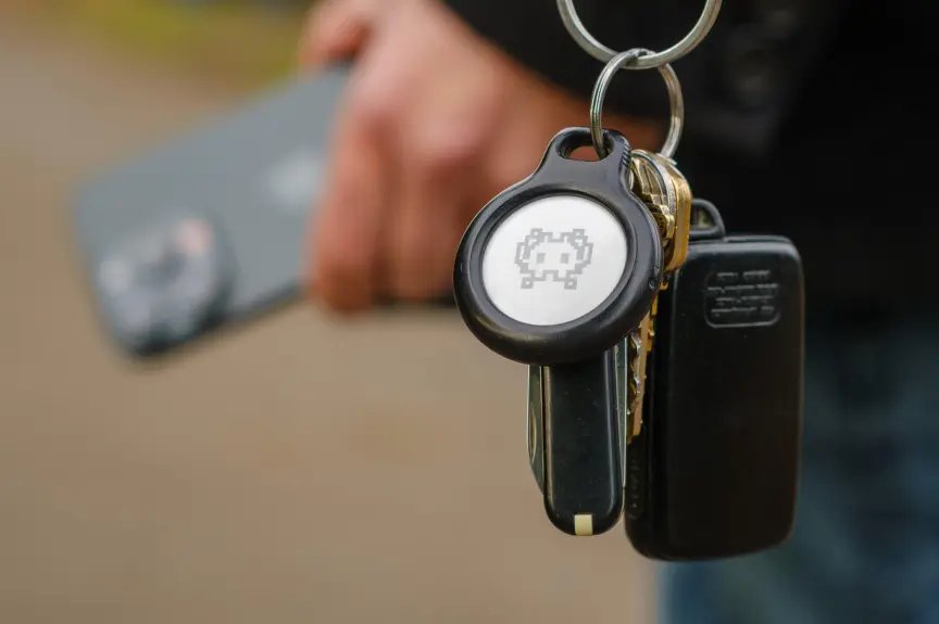 Best Apple Siri Voice Commands for Your Home: A Complete Guide 4 An AirTag on a keychain worn by a person carrying iPhone.