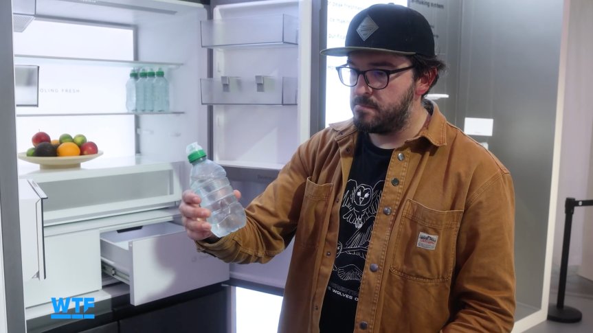 I Went Shopping for My Ultimate Smart Home of the Future at IFA 2026 4 The writer looking confused at a water bottle that has come out of an extremely cold fridge showcased at IFA.