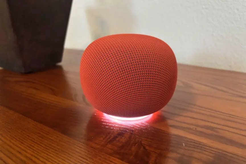 I Tested the Three Big Voice Assistants to See Who’s Best at Predicting Weather 2 A red Google Home speaker on a wood desk next to a pot.